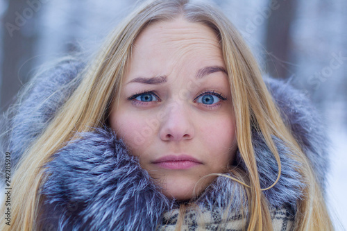Portrait. Beautiful blonde girl smiling, weighs in winter weather.