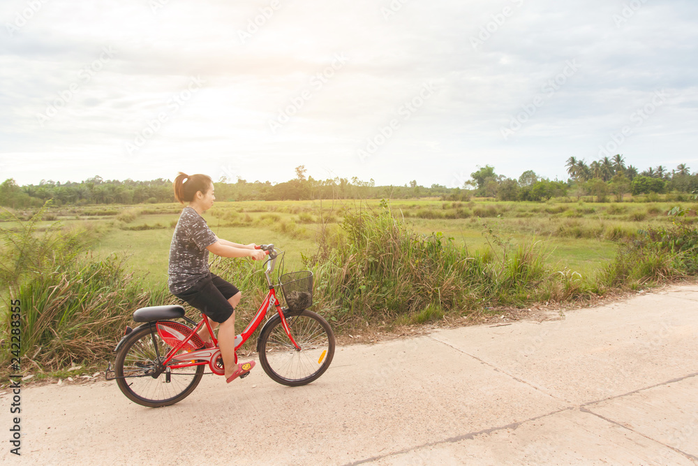 Obraz premium Woman riding bicycle relax in a country road.