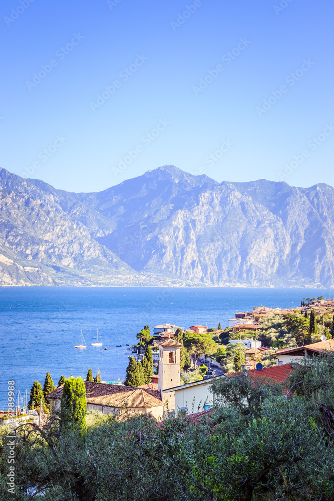 Idyllic coastline in Italy: Blue water and a cute village at lago di garda, Malcesine, sunset