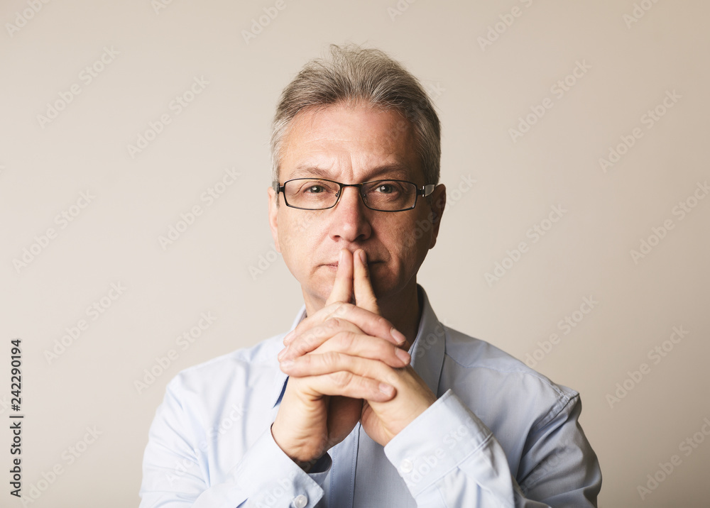 Serious senior man in glasses thinking over background Serious senior man in glasses thinking over background