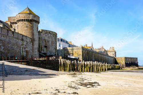 Porte Saint-Thomas, the gate of the surrounding wall of the old town of Saint-Malo, France, located at the rear of the castle of Duchess Anne of Brittany, seen from the beach on a sunny morning.