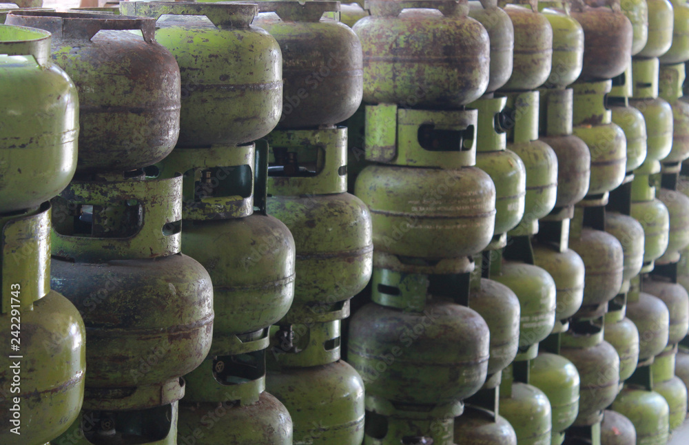 stacked liquified petroleum gas in green steel metal bottle storage