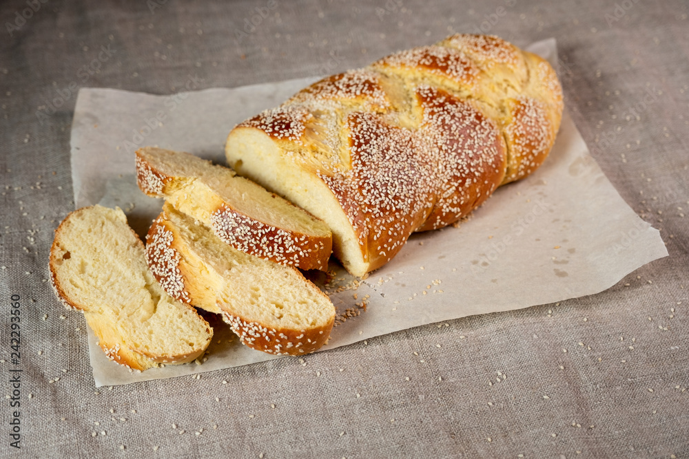 Fresh sliced challah jewish bread on paper over linen cloth Fresh sliced challah jewish bread on paper over linen cloth
