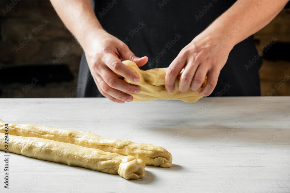 Male baker making traditional challah jewish bread. Cooking steps process food concept. Male baker making traditional challah jewish bread. Cooking steps process food concept.