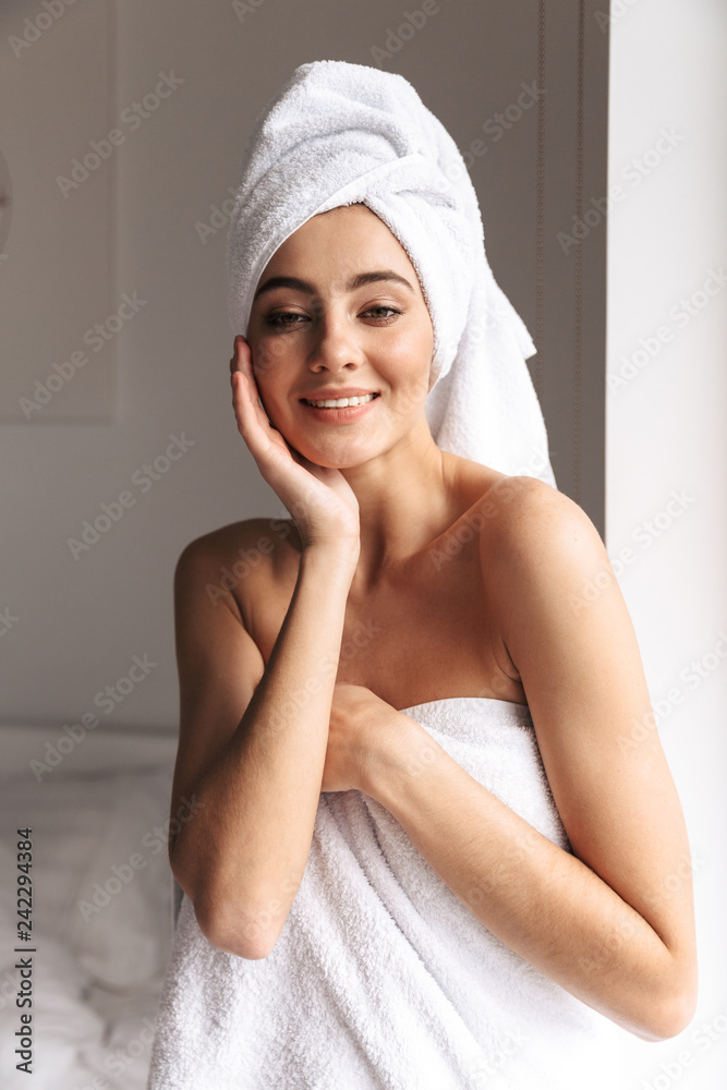 Photo of attractive woman wearing white towel, while standing in bathroom after shower in flat Photo of attractive woman wearing white towel, while standing in bathroom after shower in flat