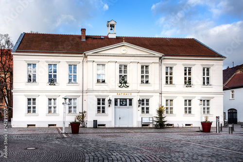 Germany, Prignitz, Pritzwalk: Panorama front view of town hall in the city center of the small German town with main entrance, public square and blue sky - concept administration. photo