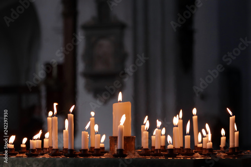 Фотография Many flames on candles lit in the church in respect