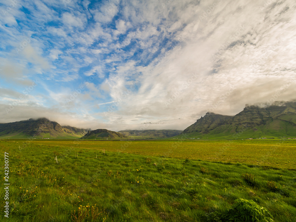 Obraz premium Beautiful icelandic landscape with mountains and green fields.