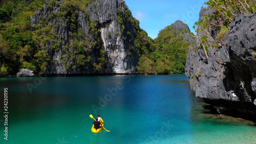 people on a canoe in lagoons with cliffs, philippines