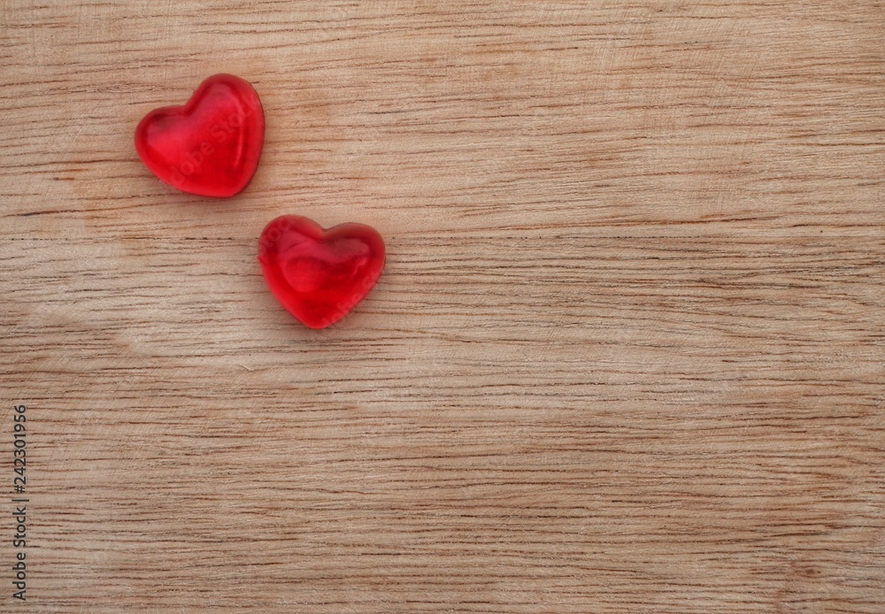 Two heart shaped jellies on wooden material Two heart shaped jellies on wooden material
