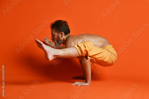 Sporty senior man doing Arm balance exercise for strength, yoga, pilates training, photo