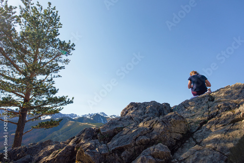 Girl sit on the rock with landscape background view, clear blue sky. - Image
