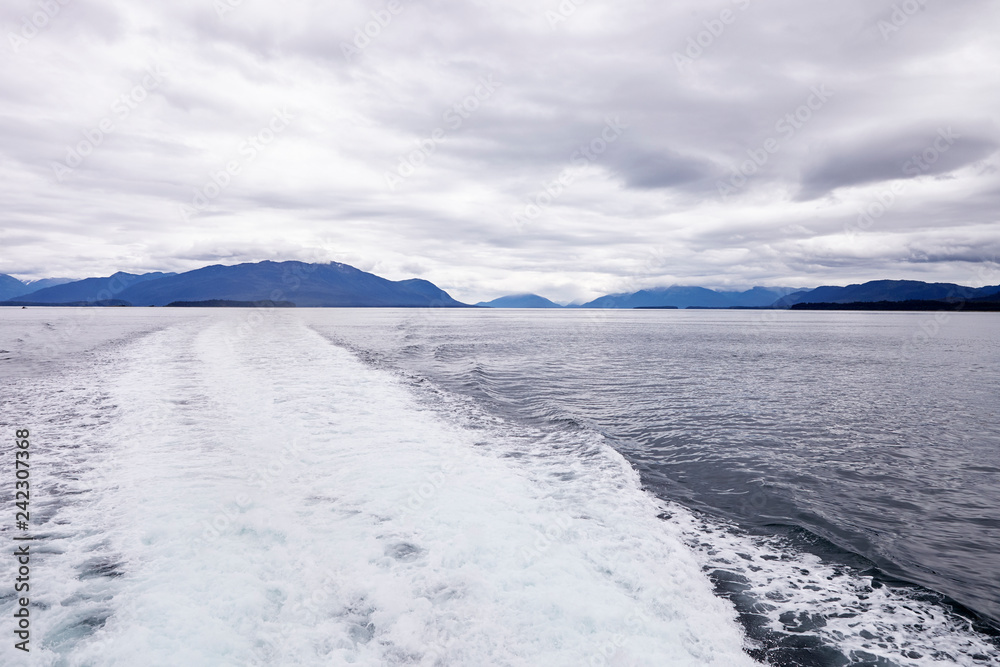 Wake Of Boat On Lake In Alaska Surrounded By Mountains And Forests