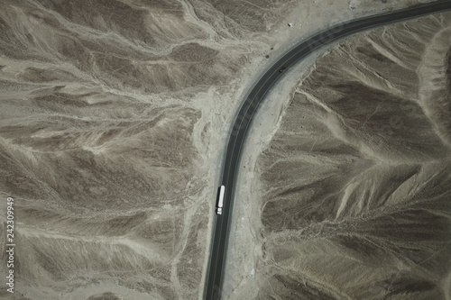 A white truck runs on the pan-American Highway through Nazca desert in Peru.