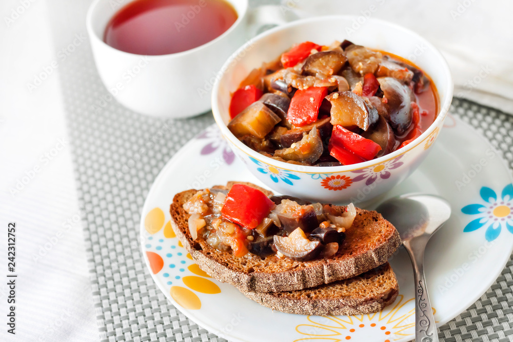 Vegetable stew with eggplant, red pepper and tomatoes on toasted rye bread