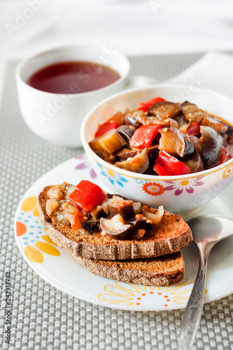 Vegetable stew with eggplant, red pepper and tomatoes on toasted rye bread