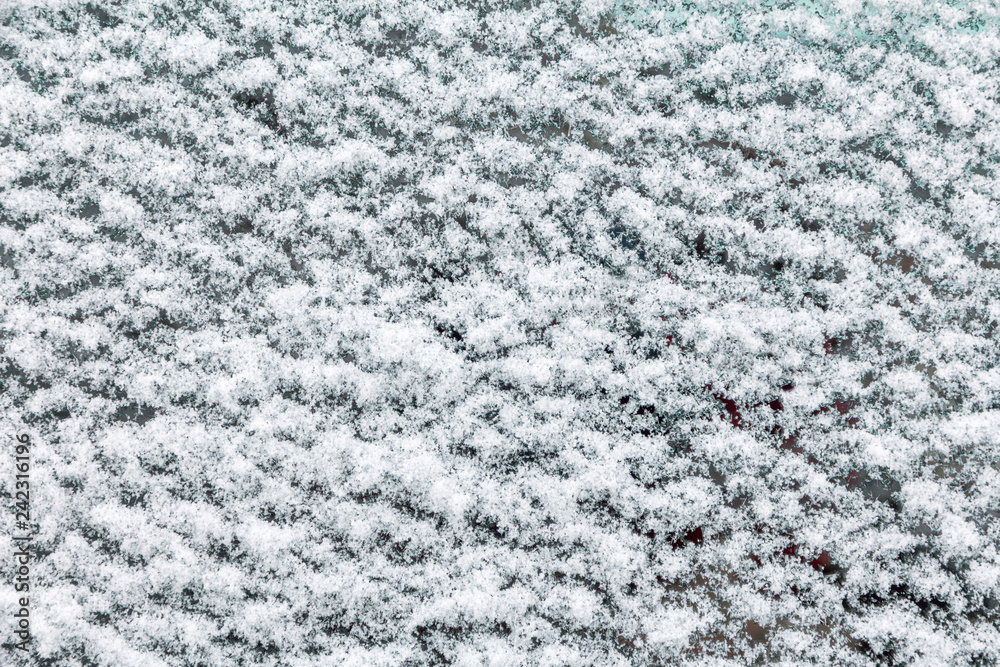 snow texture on car glass in winter day. close-up frozen car glass snow texture on car glass in winter day. close-up frozen car glass
