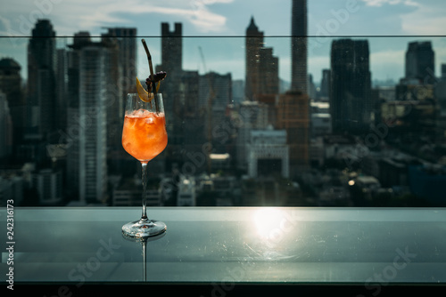 Canvas Print Cocktails glasses on the table in rooftop bar at Bangkok city view during sunset