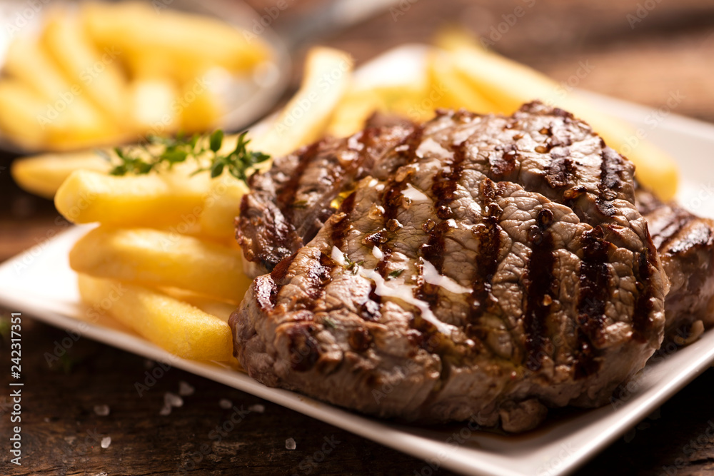 Grilled beef steak on wooden cutting board Grilled beef steak on wooden cutting board