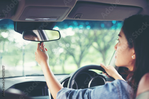 Obraz na plátne Asian women are adjusting the rearview mirror of the car