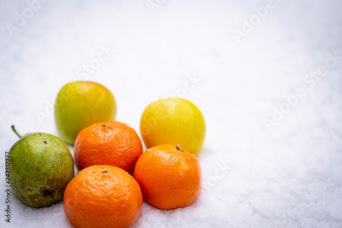 Fruits on the snow, mandarines, apples, pear © Marinka