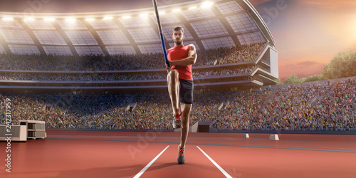 Fototapeta Młody mężczyzna sportowiec skoku o tyczce z drążkiem w linii startowej. Mężczyźni w odzieży sportowej na torze sportowym na profesjonalnym stadionie