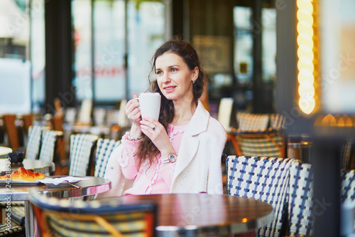 Woman drinking coffee in outdoor cafe or restaurant, Paris, France