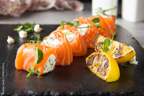 Salmon rolls stuffed with cream cheese and herbs, beautiful snack, elegant food for menu photo