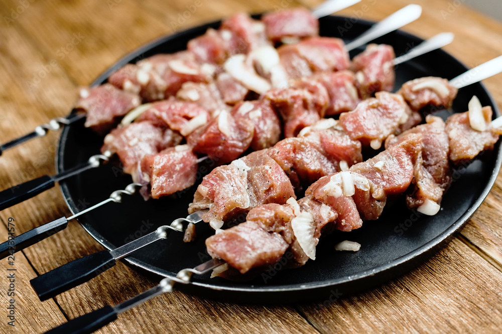 Pieces of raw meat are strung on skewers. Close-up. View from above.