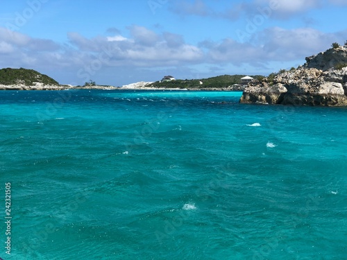 Turquoise waters of the Bahamas with rocky islands in the background