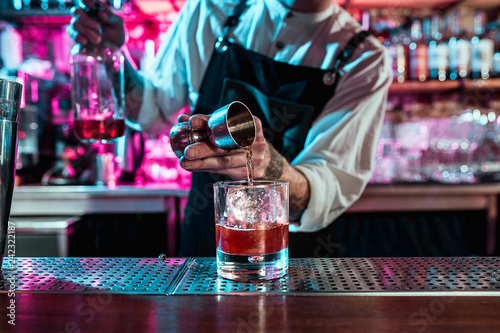 Foto Expert barman is making cocktail at night club or bar