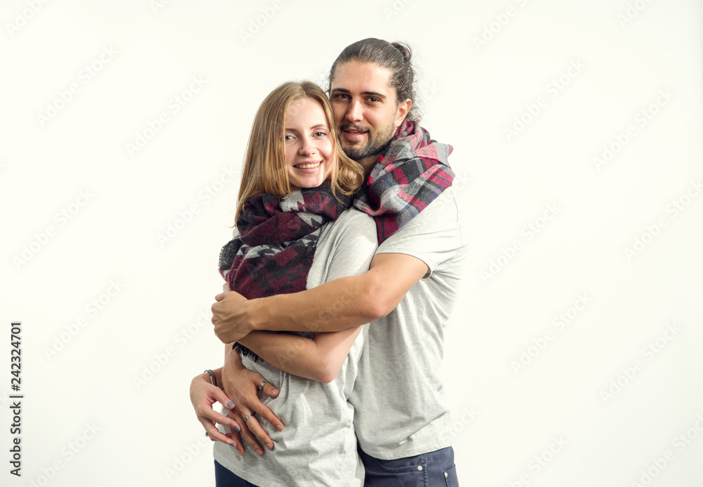 Young couple in love in shirts and scarves standing on a light background. Man and woman. Young couple in love in shirts and scarves standing on a light background. Man and woman.