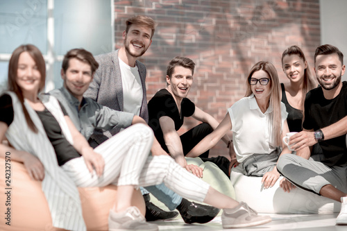 group of young people sitting on the floor in the new office