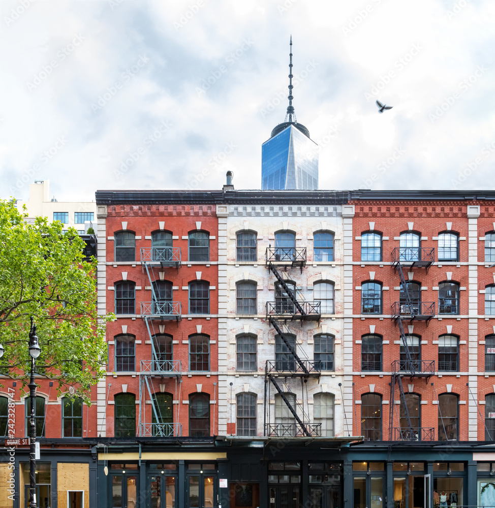 Old brick buildings on Duane Street in Tribeca contrast against modern steel skyscraper in lower Manhattan, New York City