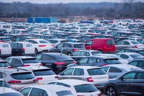 Many new cars parked in a row, ready for export