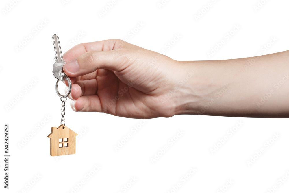 Hand holding a house key, isolated on white background