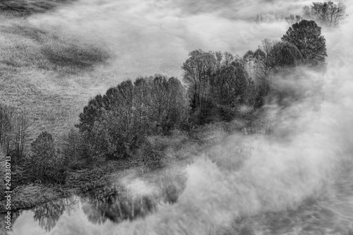Paesaggio sul fiume e sulla foresta con nebbia, fotografia in bianco e nero