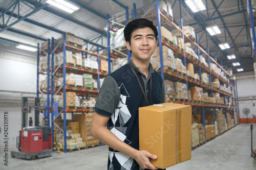 Worker carrying box in the warehouse (ฺBlur background) , Asian delivery man carrying boxes in the distribution warehouse (ฺBlur background)