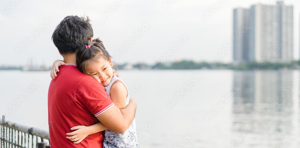 Little Girl resting on her father's shoulder near the river.Happy family daughter hugs his dad on holiday.Concept of Father day. Family holiday and togetherness. Little Girl resting on her father's shoulder near the river.Happy family daughter hugs his dad on holiday.Concept of Father day. Family holiday and togetherness.
