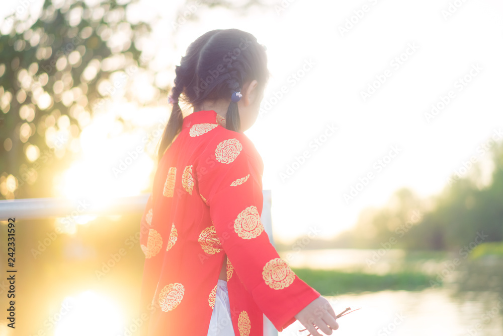 4 years old asian chinese child girl.Happy Little asian girl in chinese traditional dress smiling and holding red envelope.Happy chinese new year concept