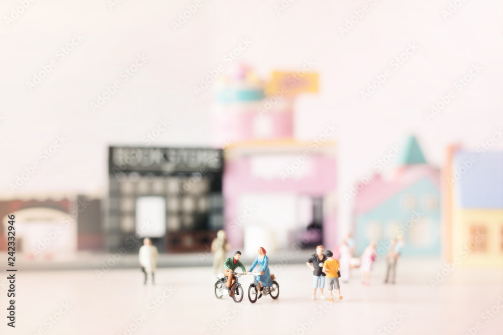 Happy young couple  (miniature) on cycle ride (miniature) on cycle ride in the city.Valentine's day background with selective focus and soft pastel color toned.