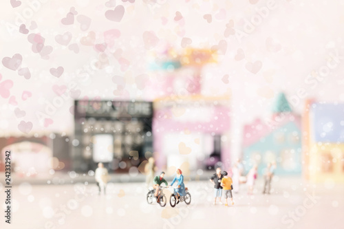 Happy young couple   miniature  on cycle ride  miniature  on cycle ride in the city.Valentine s day background with selective focus and soft pastel color toned.