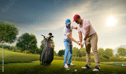 Male golf players on professional golf course. Golfer teaches to play golf