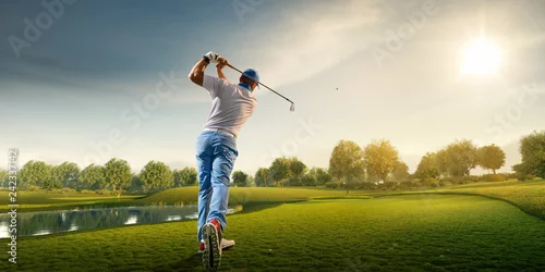 Obraz Mężczyzna golfowy gracz na profesjonalnym polu golfowym. Golfista z kijem golfowym bierze strzał