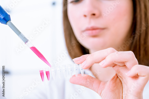 Young woman fill PCR microtubes with dispenser photo