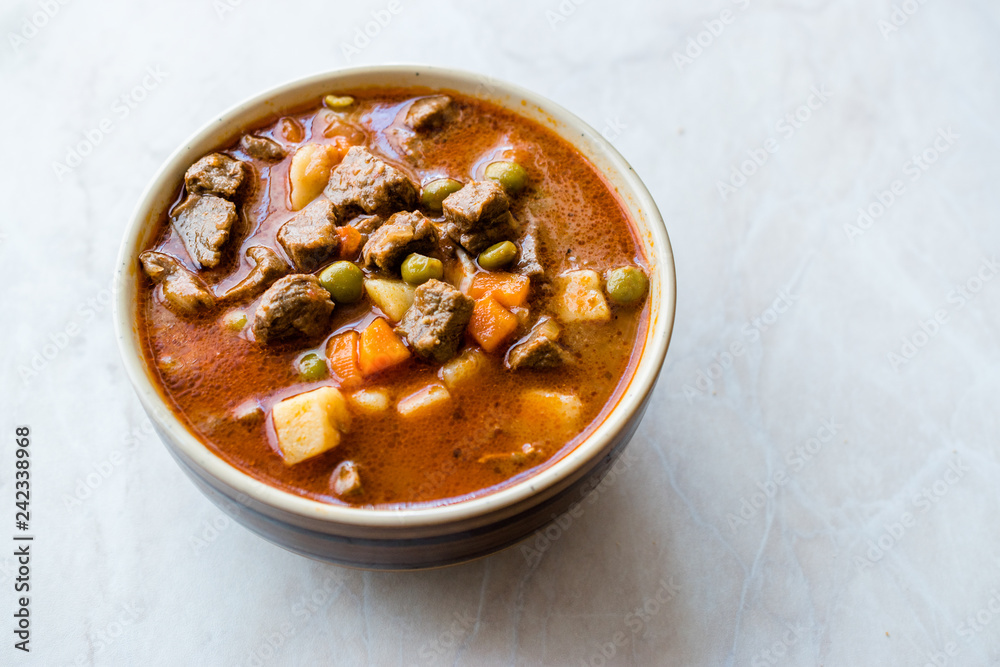 Tasty Hungarian Hot Goulash Soup Bograch or Gulas Lamb Meat Stew with Whole Grain Bread on Wooden Surface at Restaurant. Traditional Food. Tasty Hungarian Hot Goulash Soup Bograch or Gulas Lamb Meat Stew with Whole Grain Bread on Wooden Surface at Restaurant. Traditional Food.
