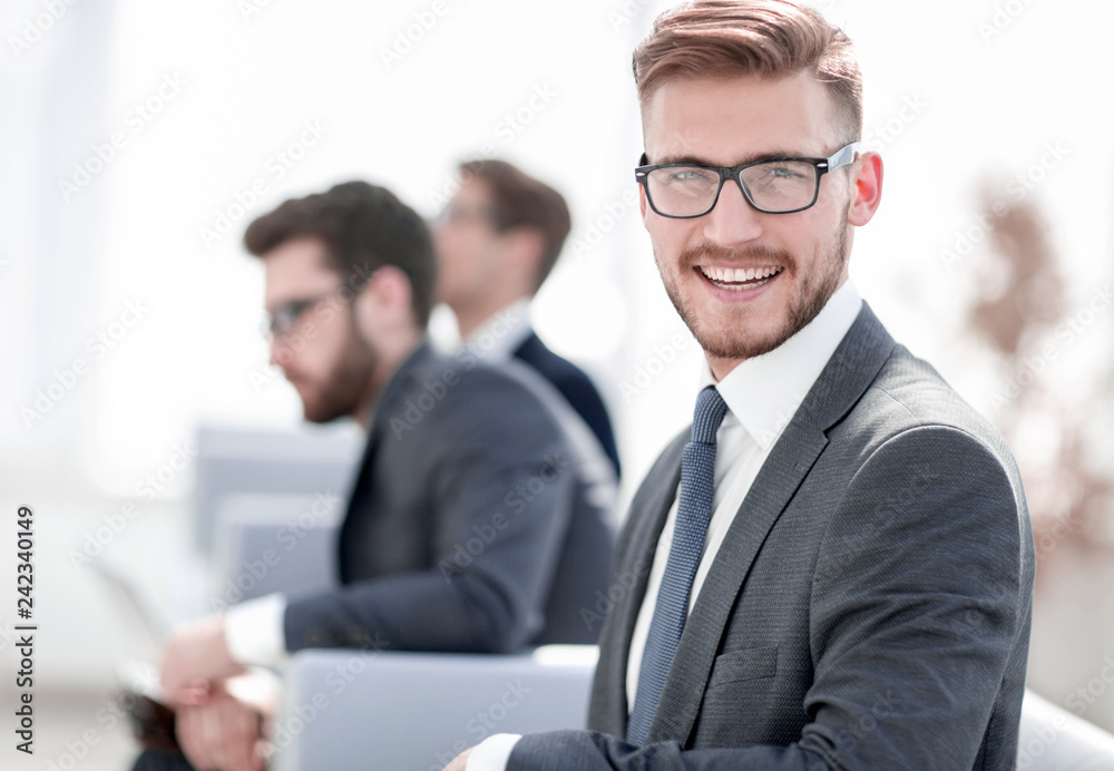 smiling businessman on blurred office background