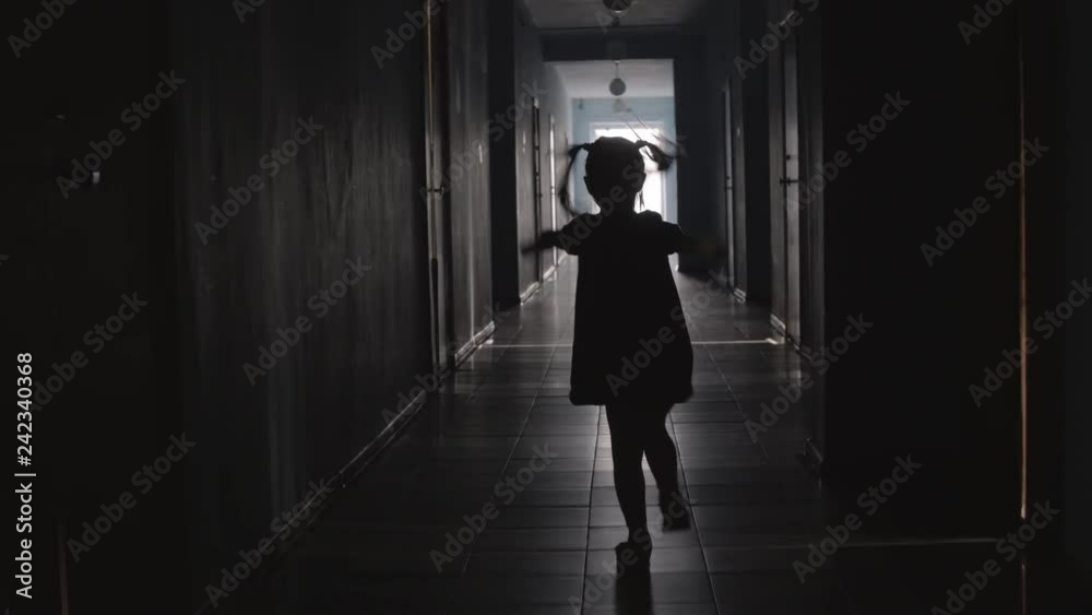Rear view of silhouette of playful little girl wearing dress jumping the rope along hallway Rear view of silhouette of playful little girl wearing dress jumping the rope along hallway