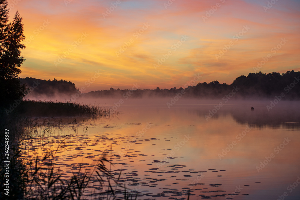 colorful misty sunset on the river in summer