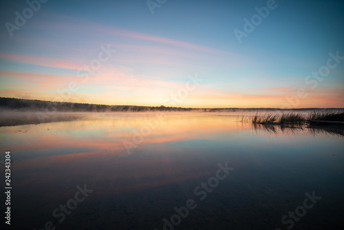 colorful misty sunset on the river in summer